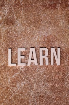 Inspirational word 'LEARN' displayed on a textured marble background.