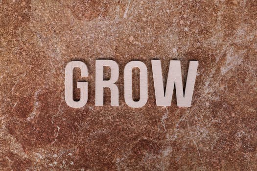 The word 'GROW' in wooden letters on a textured marble surface.